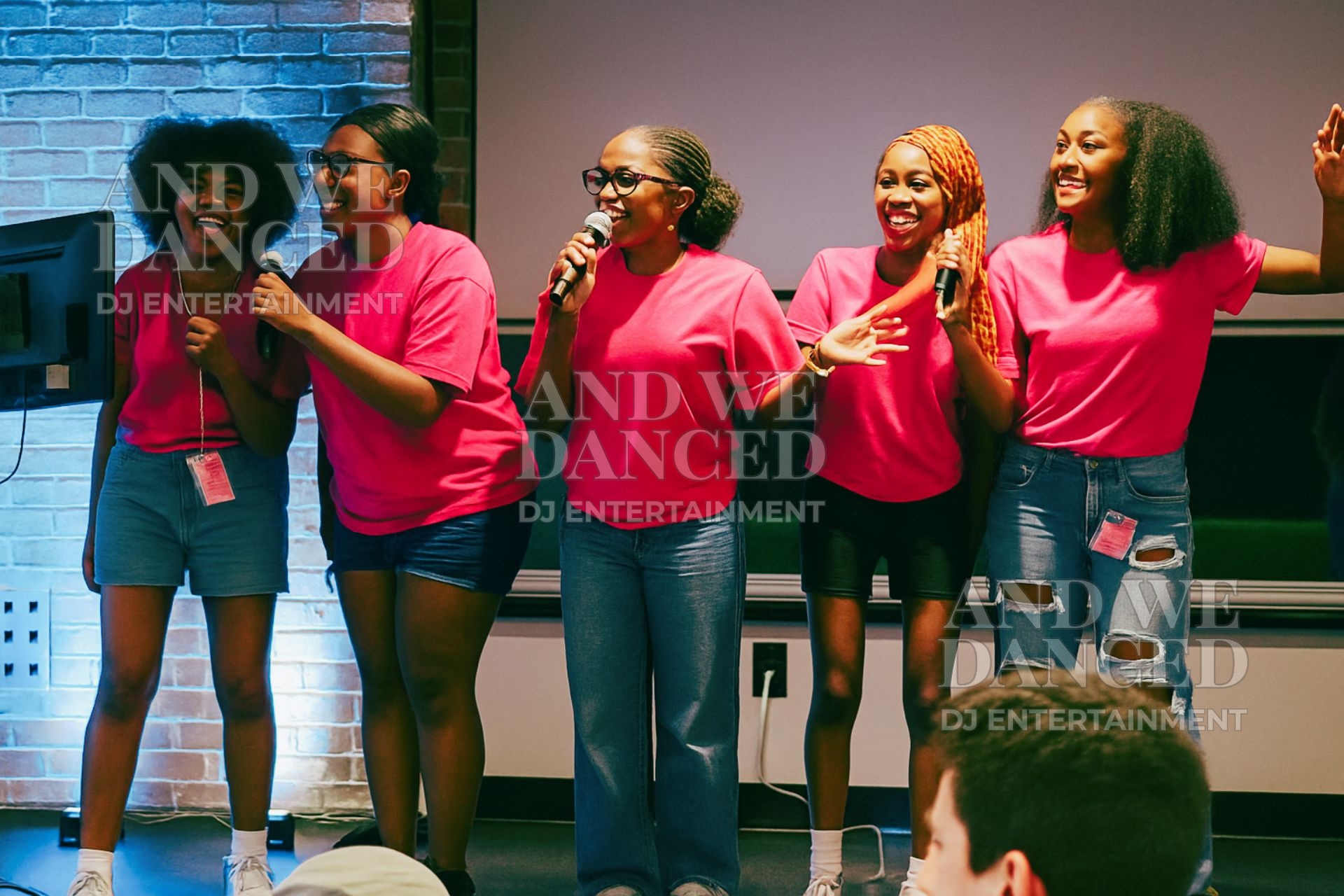Group singing karaoke on stage with blue and white uplighting